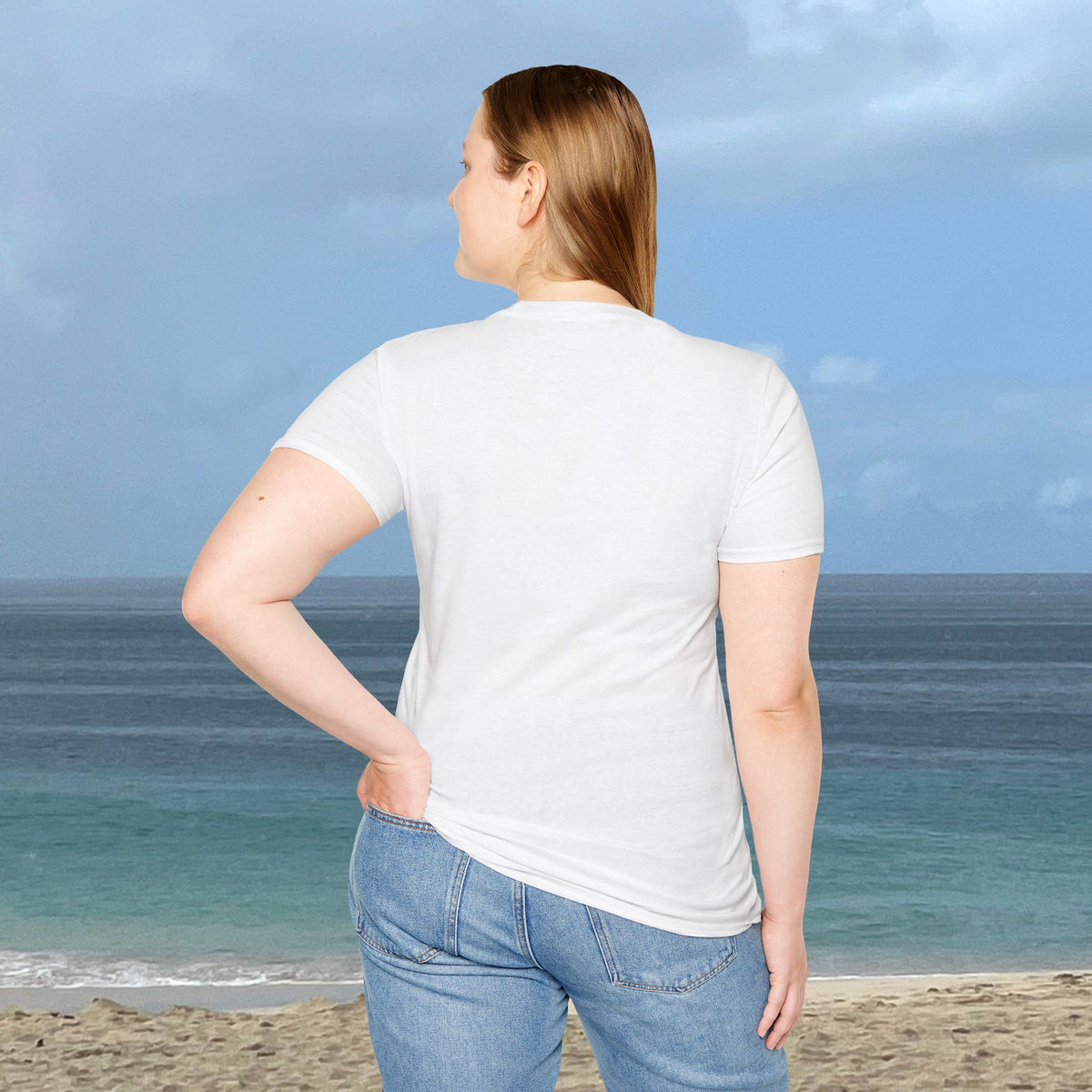 Back view of a woman wearing a plain white Coconut Tree T-shirt, standing by the ocean.