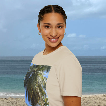 Woman wearing a natural-colored Coconut Tree T-shirt with a coconut palm photograph on the front, standing by the ocean.